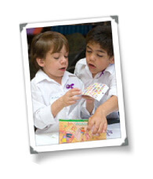 Nicholas y DiAngelo, dos niños con camisa blanca jugando y armando rompecabezas