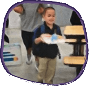 School boy carrying lunch tray in lunch hall